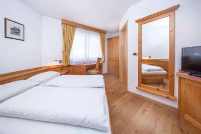 a hotel room with a bed and a television at Hotel Garni Morene in Selva di Val Gardena