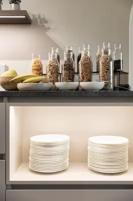 a shelf with plates and jars of food at Lingers Suites & Residence in Appiano sulla Strada del Vino