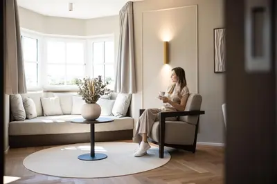 a woman sitting on a couch in a living room at Lingers Suites & Residence in Appiano sulla Strada del Vino
