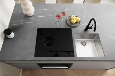 a counter top with a sink and a bowl of fruit at Lingers Suites & Residence in Appiano sulla Strada del Vino