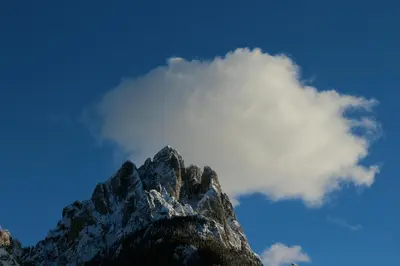 a mountain peak with a cloud in the sky at Appartamenti Casari in Pozza di Fassa