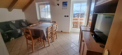 a kitchen with a table and chairs and a television at Appartamenti Casari in Pozza di Fassa