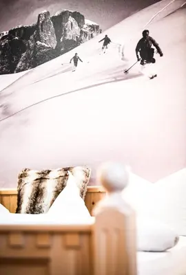 a room with skiers skiing down a snow covered slope at Garni Sunela B&B in Selva di Val Gardena