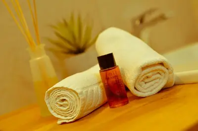 a bathroom with a towel and a bottle of sunscreen at Garni Sunela B&B in Selva di Val Gardena