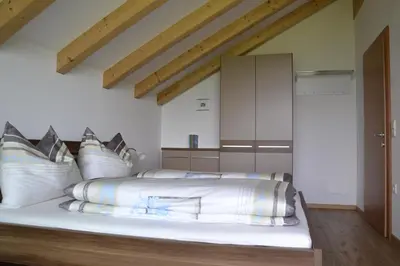 a bedroom with a large bed with white pillows at Oberberghof in Appiano sulla Strada del Vino