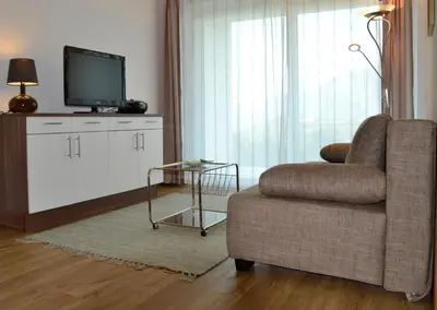 a living room with a couch and a tv and a chair at Oberberghof in Appiano sulla Strada del Vino