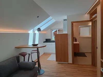 a living room with a couch and a table and a kitchen at Oberberghof in Appiano sulla Strada del Vino