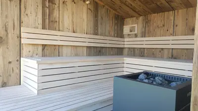 a sauna with wood paneling and a trash can at Oberberghof in Appiano sulla Strada del Vino