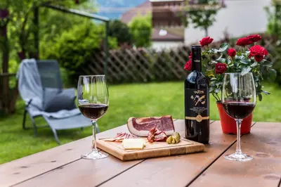 a table with two glasses of wine and cheese at Apartment Rainer in Ortisei