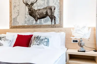 a bedroom with a bed with a deer picture on the wall at Apartment Rainer in Ortisei