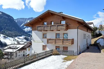 a house in the mountains with snow at Apartment Rainer in Ortisei