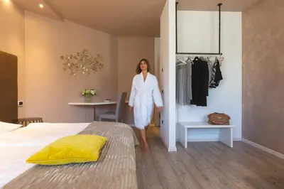 a woman standing in a bedroom with a bed at Relais Villa Quercia in Tassullo