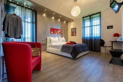 a bedroom with a bed and a red couch at Relais Villa Quercia in Tassullo
