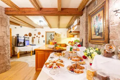 a kitchen with a table with plates of food on it at Relais Villa Quercia in Tassullo