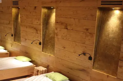 a bedroom with two beds and wooden walls at Hotel Castel Pietra in Fiera di Primiero