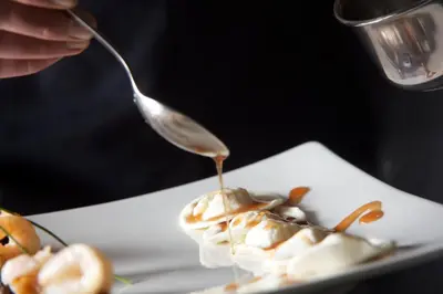 a person eating food on a plate with a spoon at Hotel Castel Pietra in Fiera di Primiero