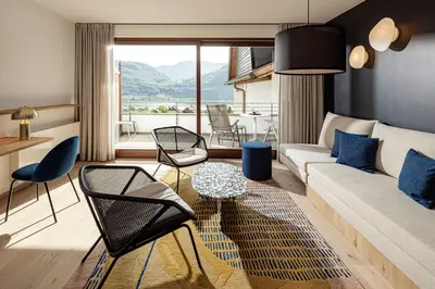a living room with a couch and chairs and a table at Hotel Haus am Hang in Caldaro