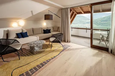 a living room with a couch and a table at Hotel Haus am Hang in Caldaro