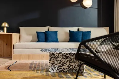 a living room with a couch with blue pillows at Hotel Haus am Hang in Caldaro