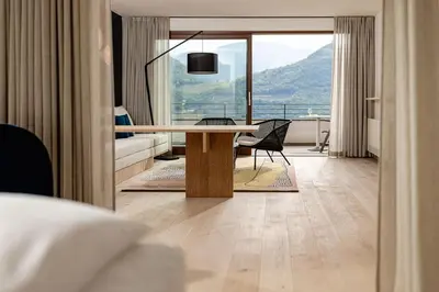 a living room with a table and a couch at Hotel Haus am Hang in Caldaro
