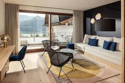 a living room with a couch and a table and chairs at Hotel Haus am Hang in Caldaro