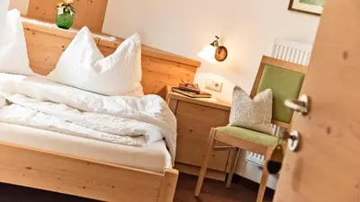 a bedroom with a bed and a desk and a chair at Garni Pramstrahler in Chiusa