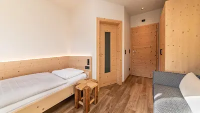 a room with a bed and a chair in it at Garni Pramstrahler in Chiusa
