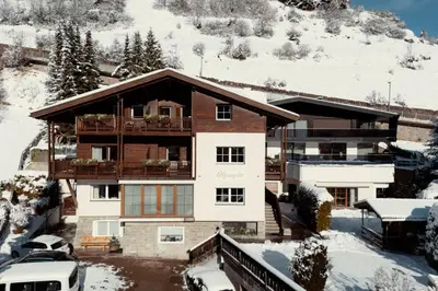 a house with a balcony in the snow at Appartamenti Insam in Santa Cristina in Val Gardena