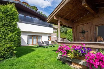 a garden with purple flowers and a house at Appartamenti Insam in Santa Cristina in Val Gardena