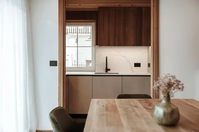 a kitchen with a wooden table and a vase of flowers at Appartamenti Insam in Santa Cristina in Val Gardena