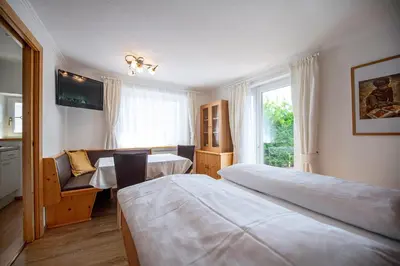 a hotel room with two beds and a window at Appartamenti Insam in Santa Cristina in Val Gardena