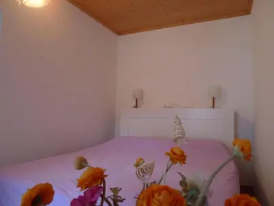 a bedroom with a bed with flowers on it at Appartamento San Marco in Caprile