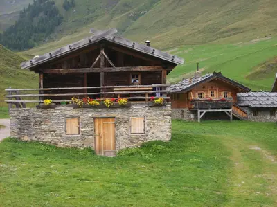 a building in a field with flowers on it at Appartamento San Marco in Caprile