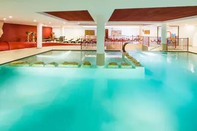 a pool in a hotel with blue water at Hotel Almina in Racines