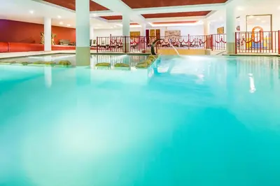 a swimming pool in a hotel with blue water at Hotel Almina in Racines