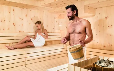 a man and a woman in a sauna at Hotel Almina in Racines
