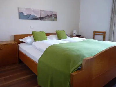 a bedroom with a large bed with green sheets at Gasthof Albergo Kreuzwirt in Fiè