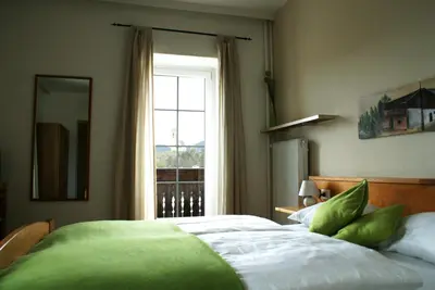a bedroom with a large bed and a window at Gasthof Albergo Kreuzwirt in Fiè