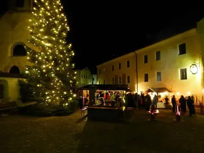 a christmas tree in front of a building at night at Gasthof Albergo Kreuzwirt in Fiè