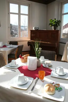 a table with a white table cloth and a piano at Gasthof Albergo Kreuzwirt in Fiè