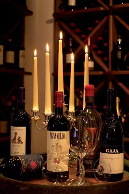 a group of bottles of wine on a table with candles at Hotel Armin in Selva di Val Gardena