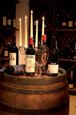 a group of wine bottles and glasses on a barrel at Hotel Armin in Selva di Val Gardena