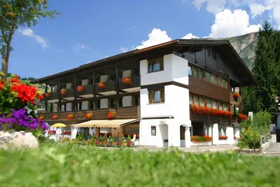a large building with flowers in front of it at Hotel Armin in Selva di Val Gardena