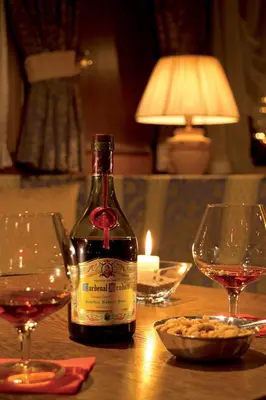 a bottle of wine sitting on a table with two glasses at Hotel Armin in Selva di Val Gardena