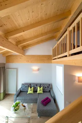 a living room with a couch and a glass table at Hotel Regglbergerhof in Nova Ponente