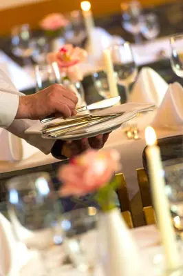 a person holding a plate at a table at Hotel Regglbergerhof in Nova Ponente