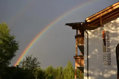 a rainbow in the sky with a building at Hotel Regglbergerhof in Nova Ponente