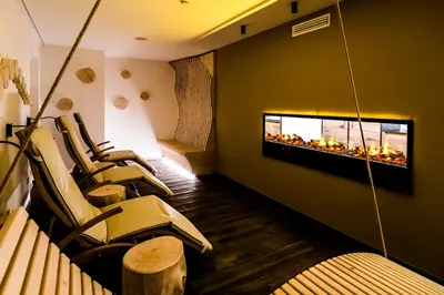 a waiting room with chairs and a fireplace at Hotel Regglbergerhof in Nova Ponente