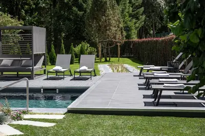 a woman is standing in the water by a swimming pool at Hotel WH - Wiesnerhof in Vipiteno