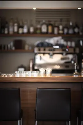 two chairs sitting at a bar with a counter at Hotel Mühlwald in Selva dei Molini